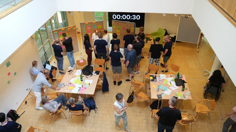 Participants gathering around session boards at a past Flight Levels Open Space